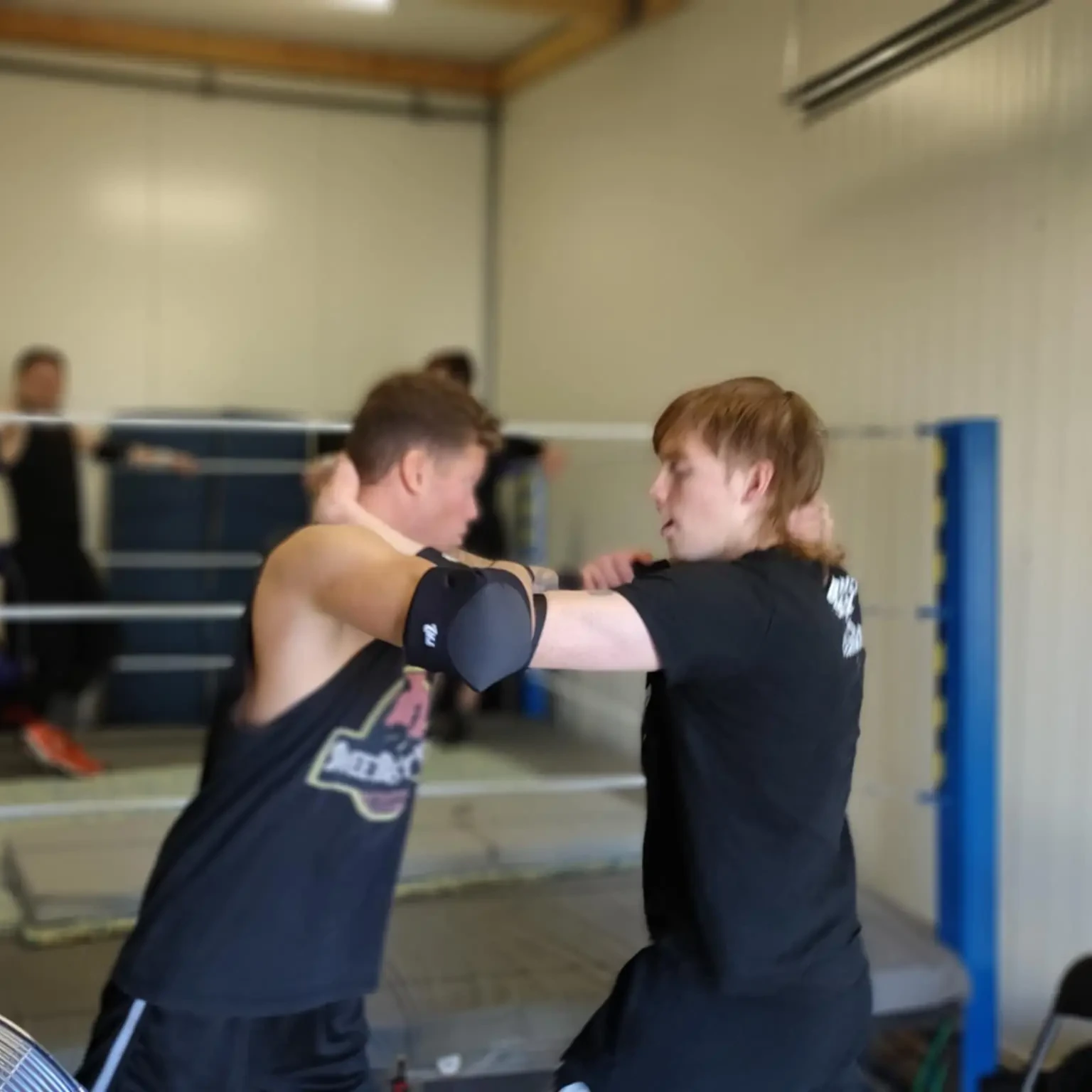 Two wrestlers locking up infront of a ring
